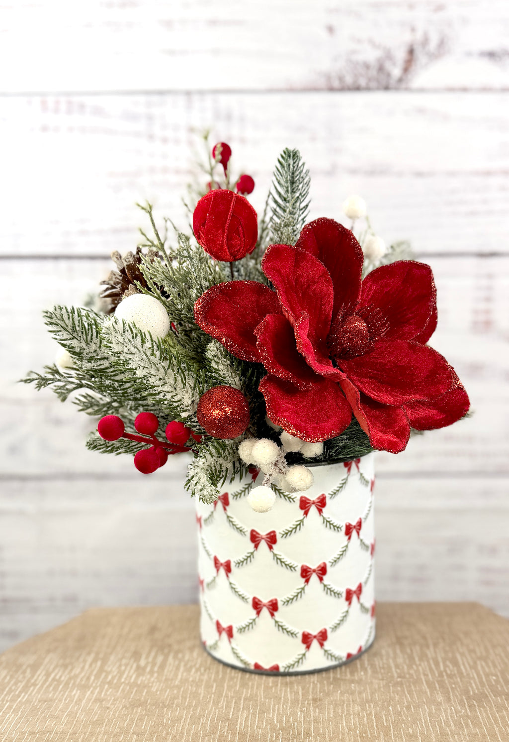 Angled view of red magnolia and bow-patterned metal tin