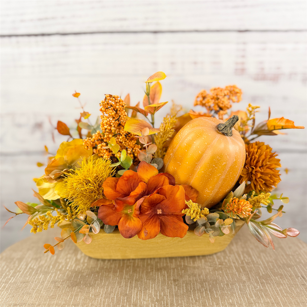 Amber Gatherings pumpkin and fall floral arrangement in a wooden dough bowl
