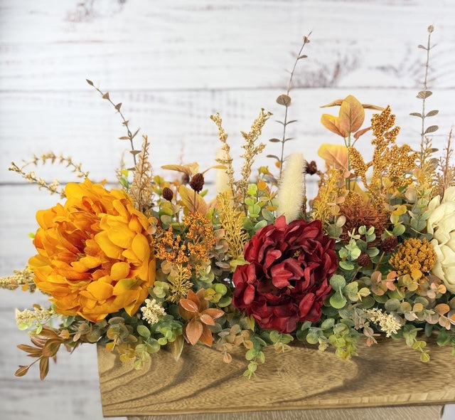 Autumn Harvest long fall floral arrangement with gold, cream and burgundy blooms in a rustic wood planter