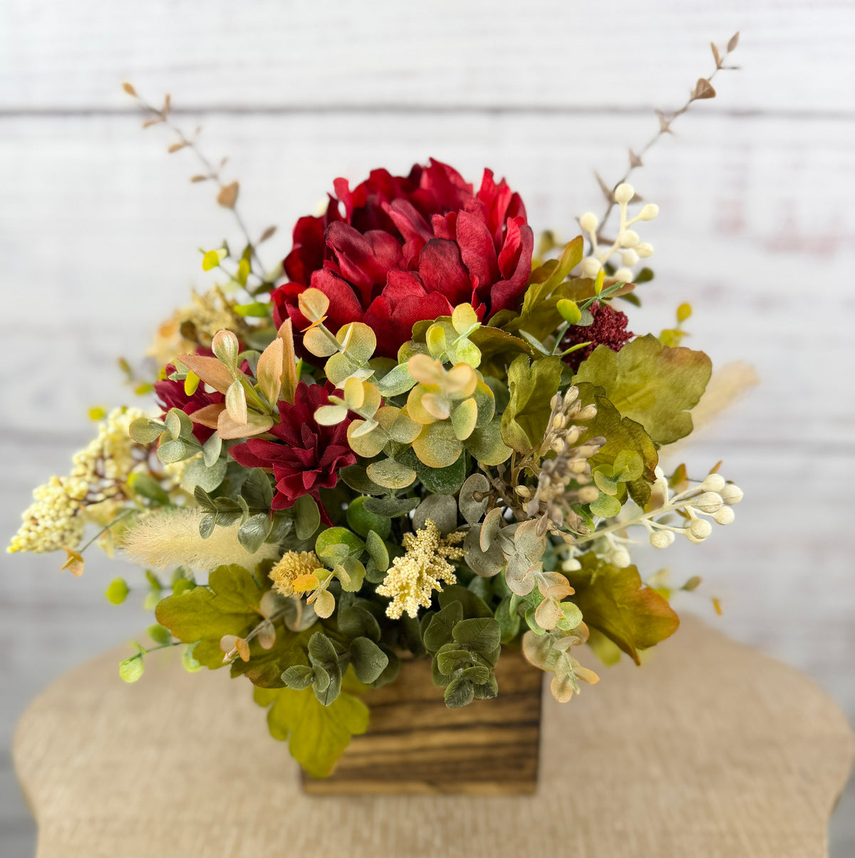Garnet Grove burgundy and cream fall floral arrangement with green foliage in a rustic wooden cube