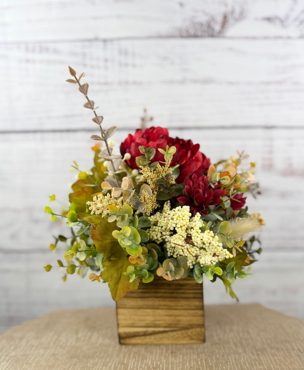 Garnet Grove burgundy and cream fall floral arrangement with green foliage in a rustic wooden cube
