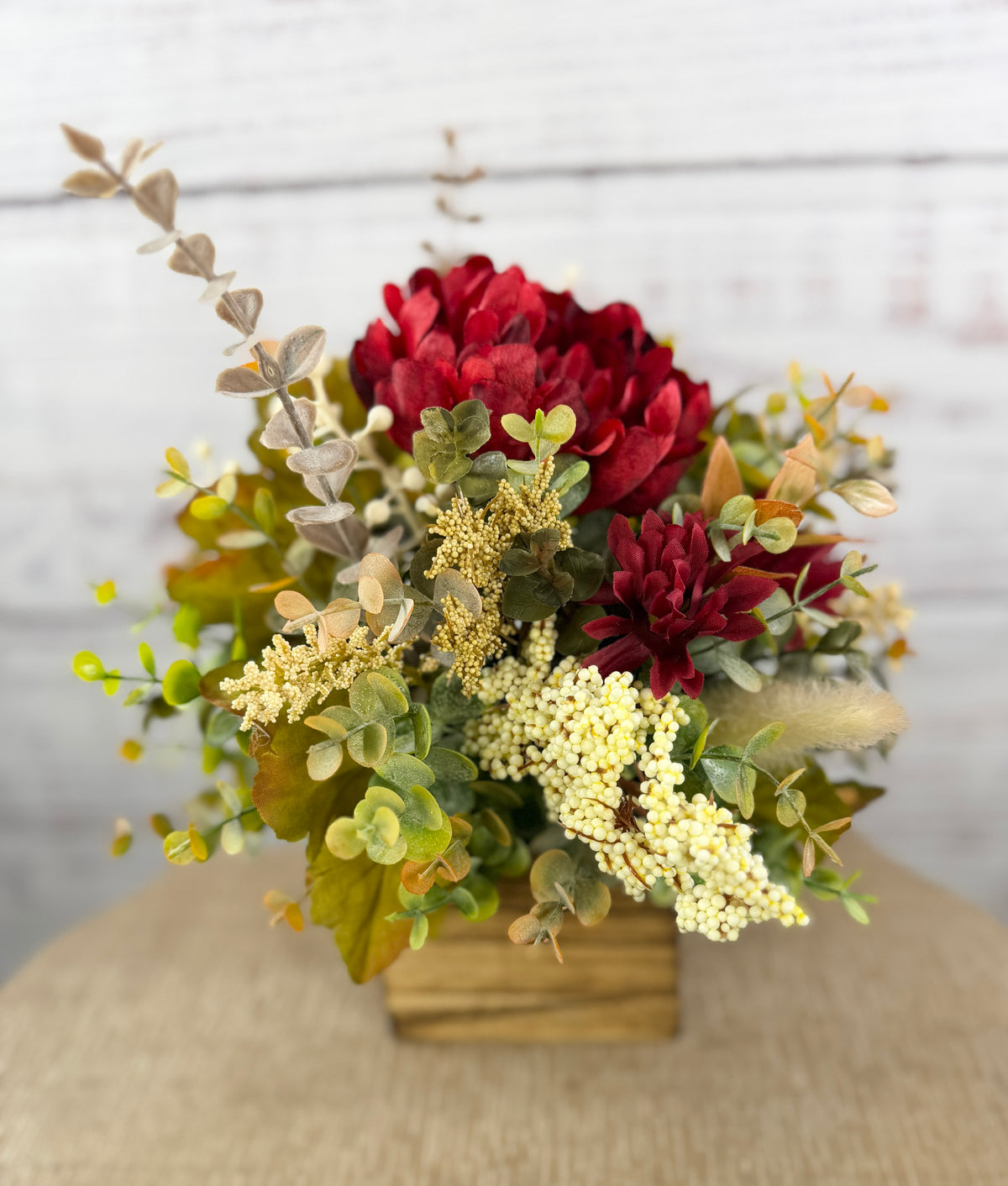 Garnet Grove burgundy and cream fall floral arrangement with green foliage in a rustic wooden cube