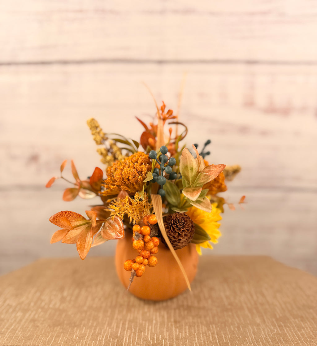 Harvest Grin smiling pumpkin with yellow and orange faux fall flowers, berries and autumn leaves