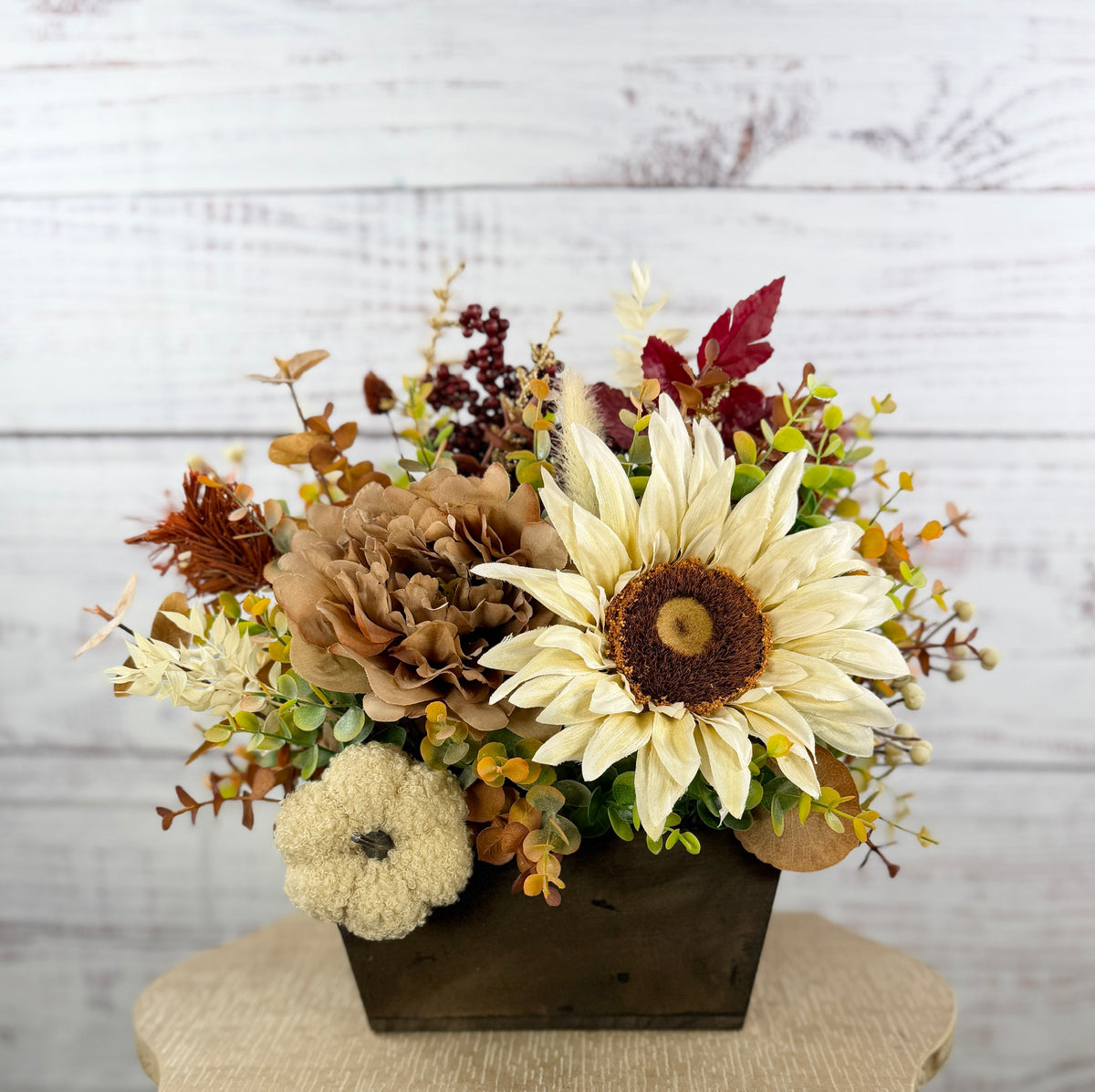 Ivory Harvest fall floral arrangement with cream and taupe flowers, autumn greenery and a decorative pumpkin in a dark wood box