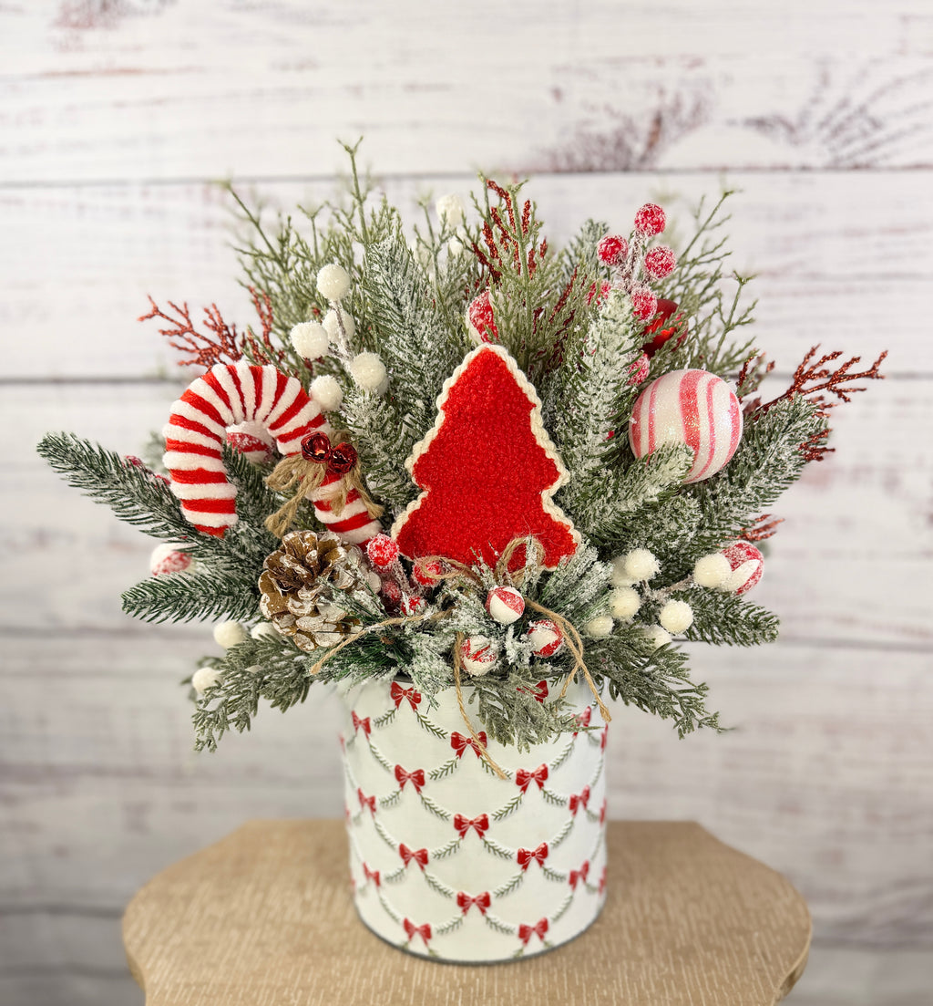 Candy cane and red tree Christmas arrangement with snowy greenery in holiday tin