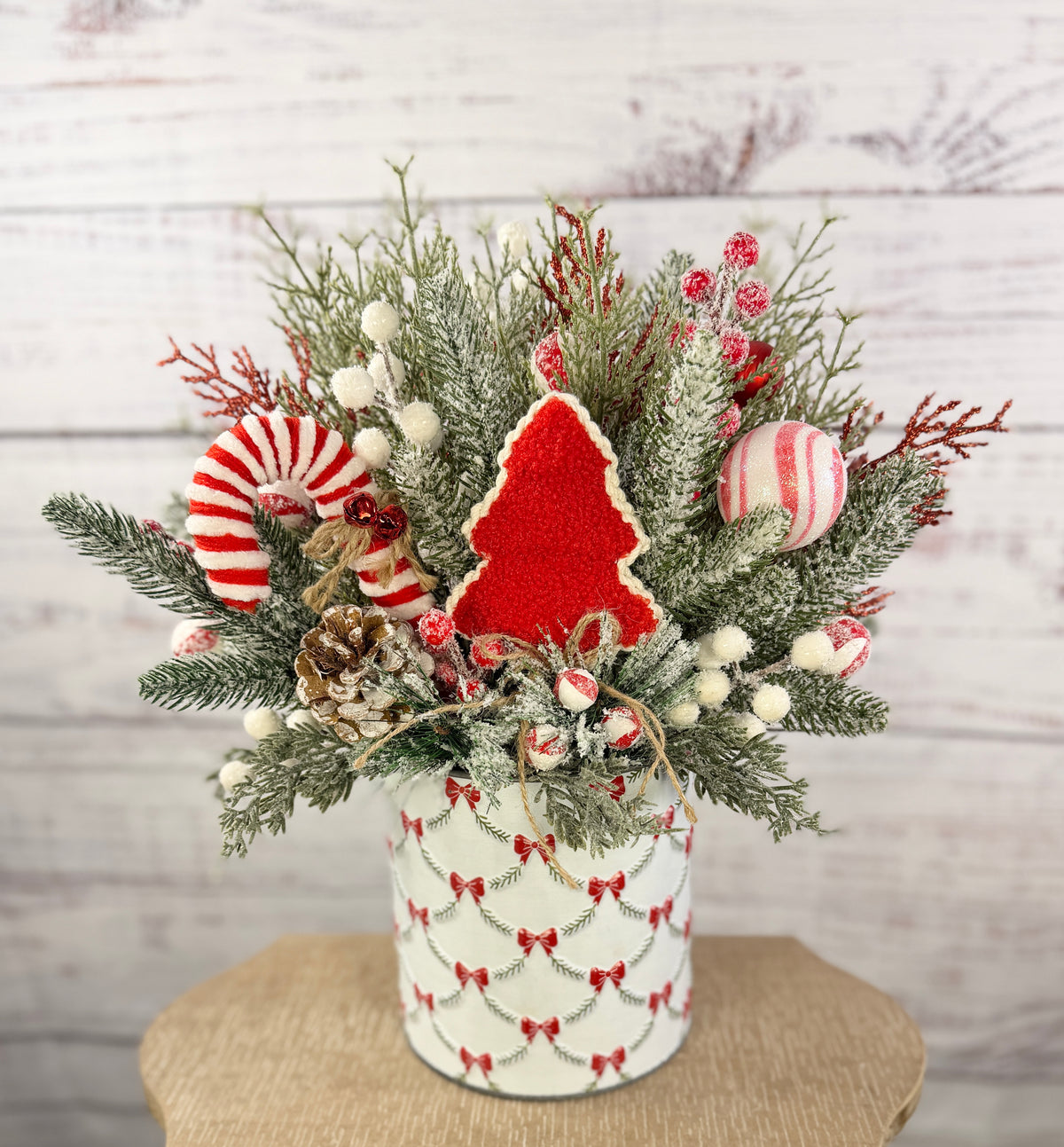 Candy cane and red tree Christmas arrangement with snowy greenery in holiday tin