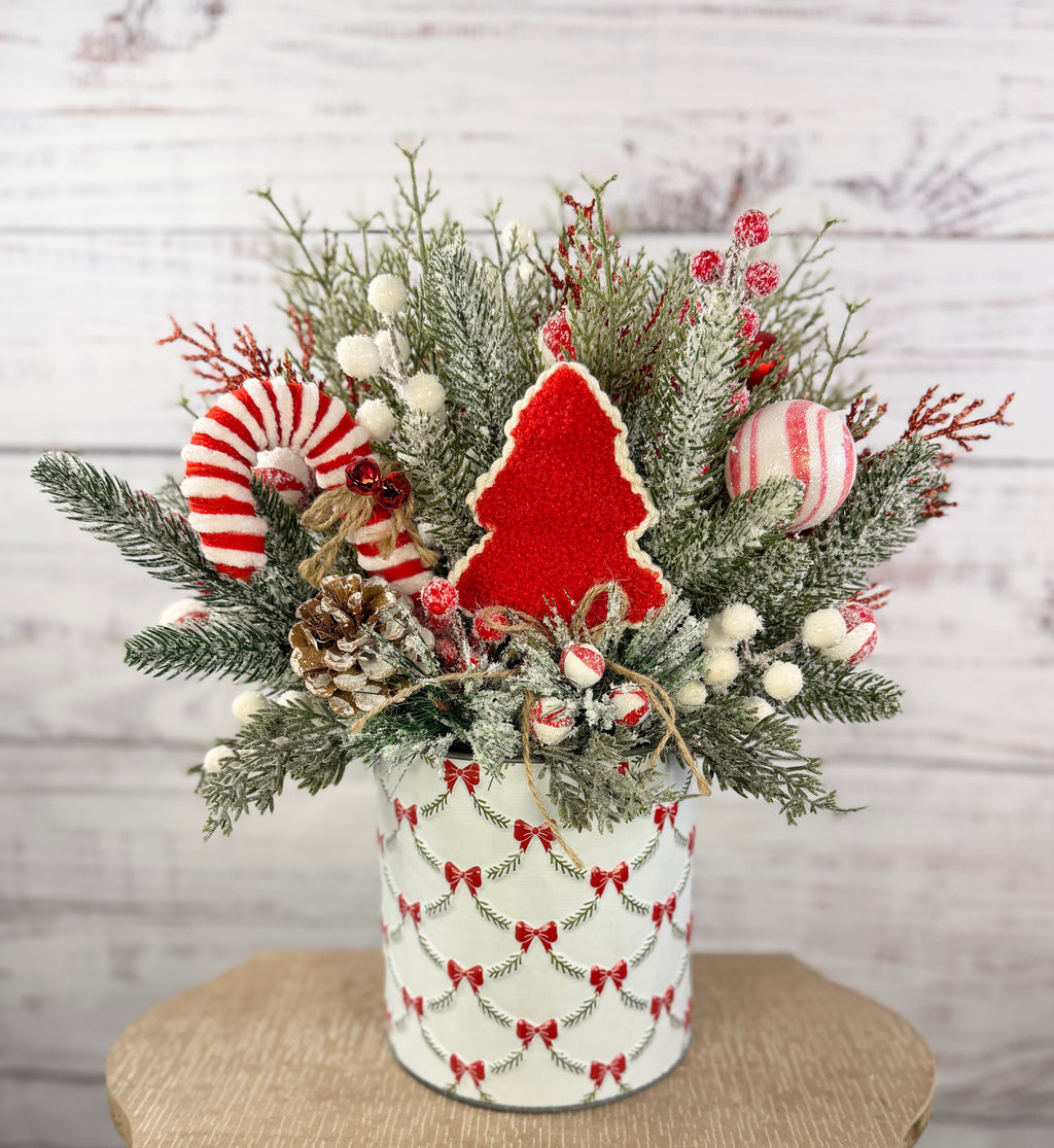Candy cane and red tree Christmas arrangement with snowy greenery in holiday tin