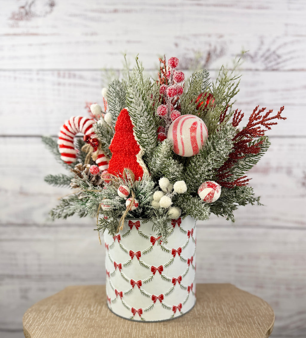 Candy cane and red tree Christmas arrangement with snowy greenery in holiday tin