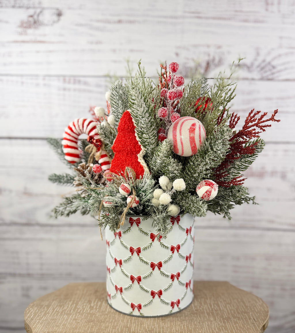 Candy cane and red tree Christmas arrangement with snowy greenery in holiday tin