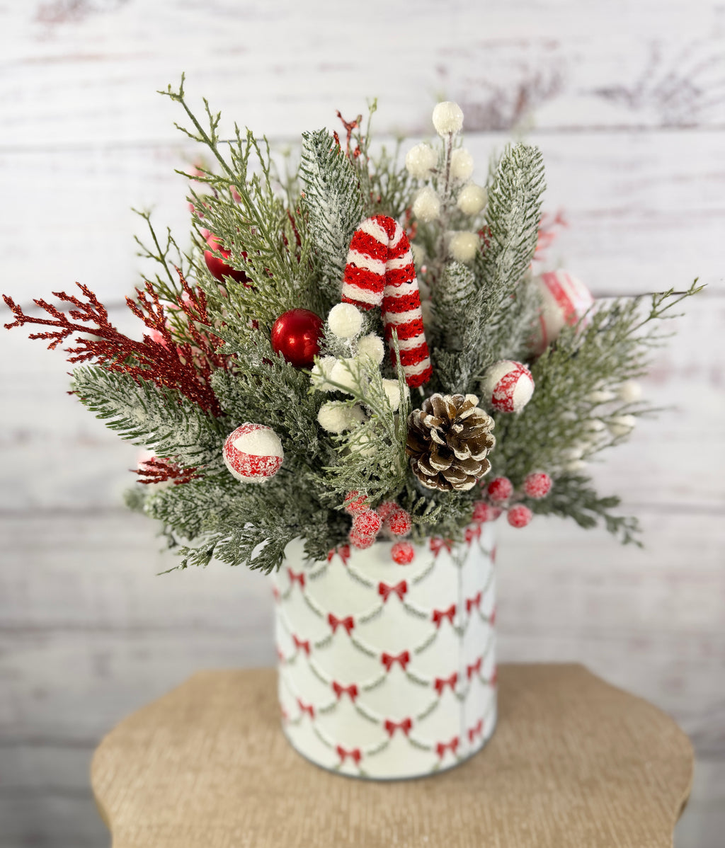 Candy cane and red tree Christmas arrangement with snowy greenery in holiday tin