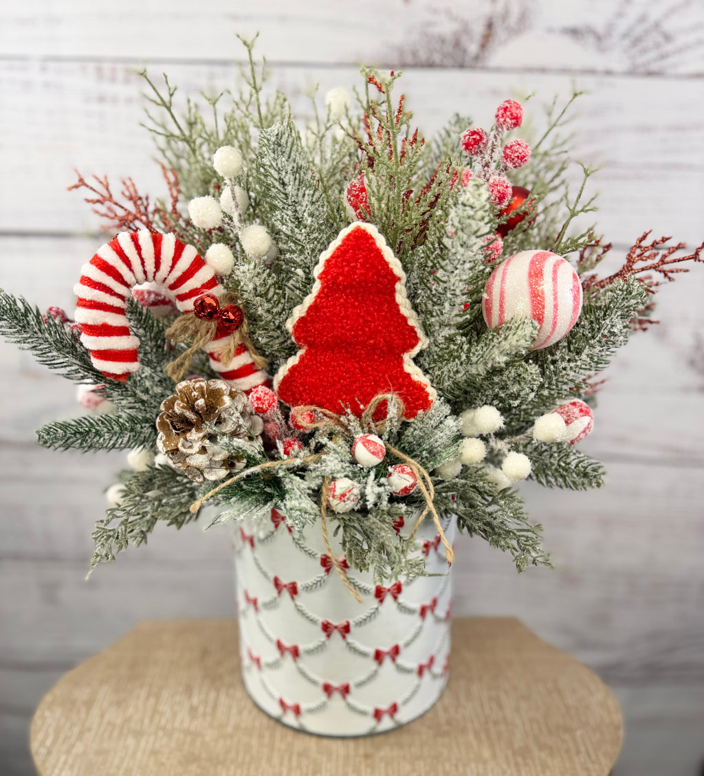 Candy cane and red tree Christmas arrangement with snowy greenery in holiday tin