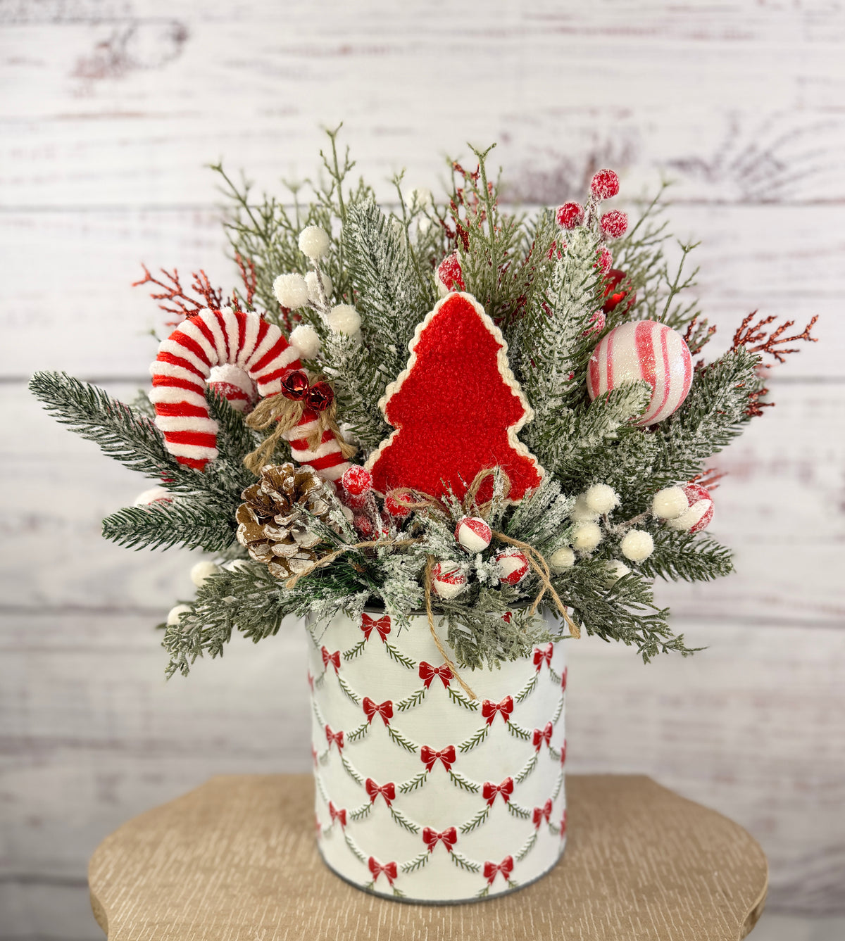 Large candy cane Christmas arrangement in white bow-patterned holiday tin