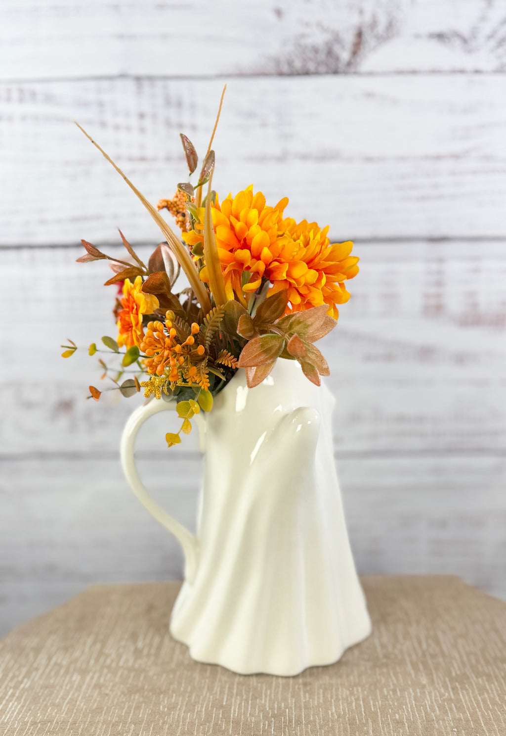 Marigold Boo ceramic ghost pitcher with orange and golden faux flowers