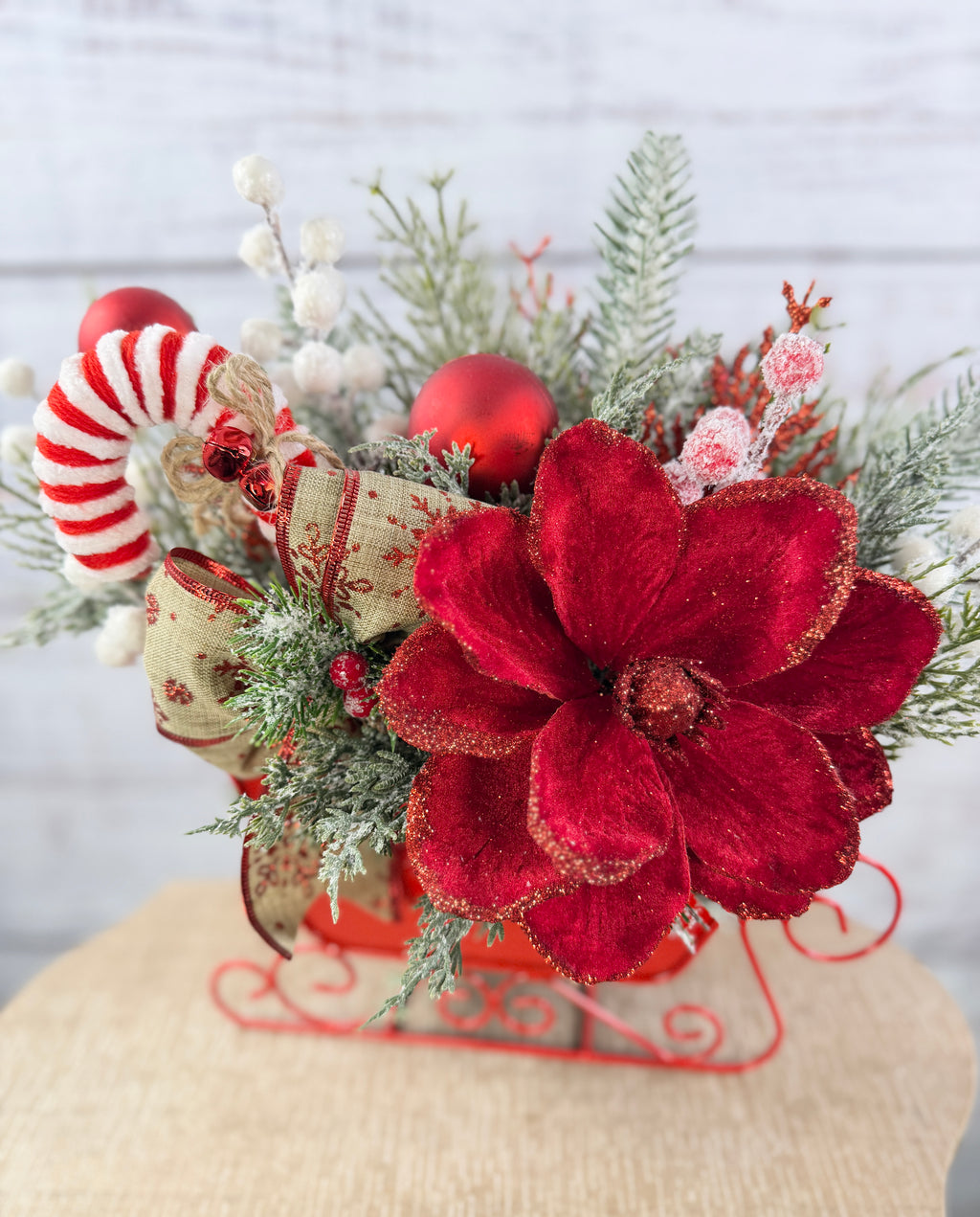 Close-up of glitter-edged red flower and festive ribbon