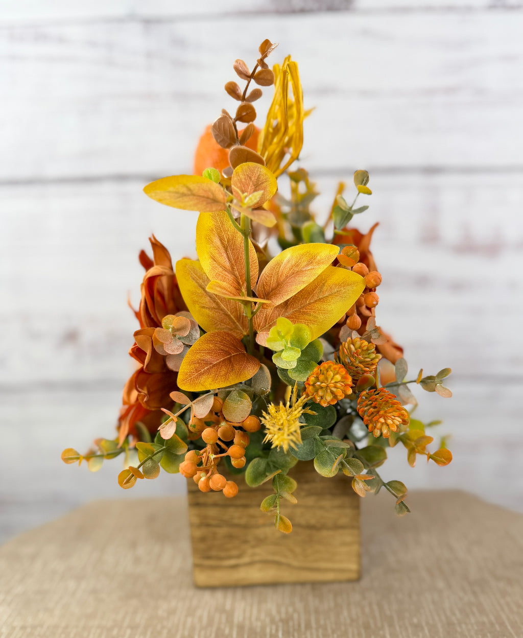 Sweet Scarecrow fall arrangement with smiling scarecrow, orange flowers and autumn foliage in a rustic wood cube box