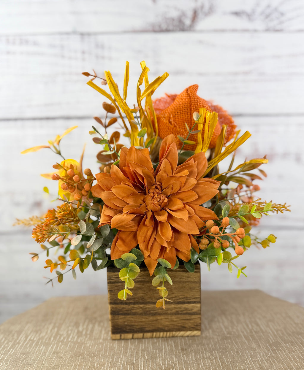 Sweet Scarecrow fall arrangement with smiling scarecrow, orange flowers and autumn foliage in a rustic wood cube box