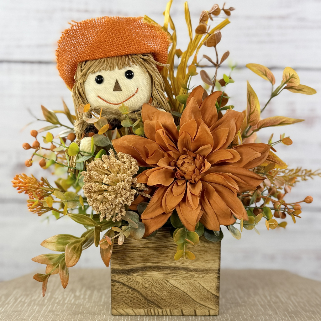 Sweet Scarecrow fall arrangement with smiling scarecrow, orange flowers and autumn foliage in a rustic wood cube box — straightened main photo